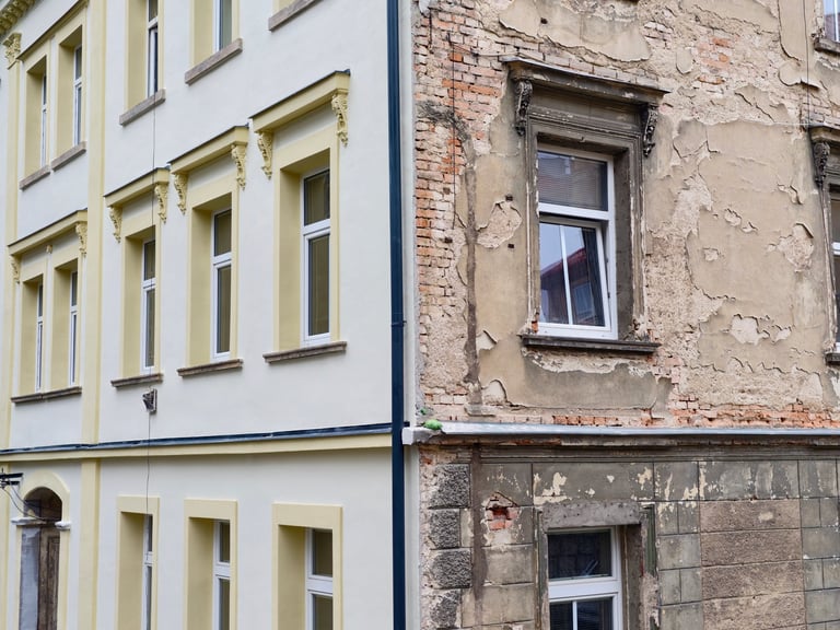Half renovated building showing contrast between decay and bright yellow plaster — inestabilidad y transformación