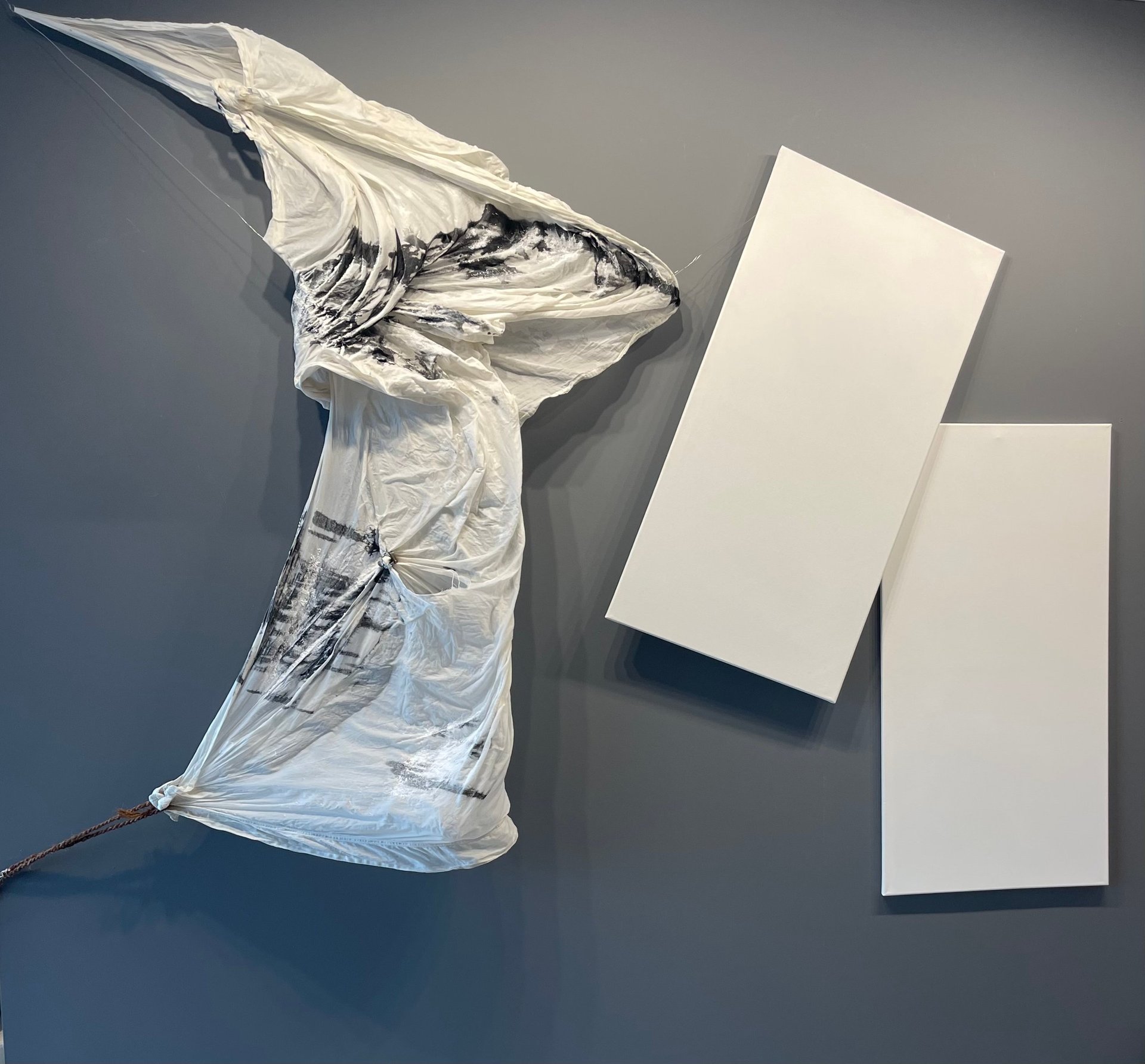 Crumpled plastic bag next to blank white business cards on gray surface