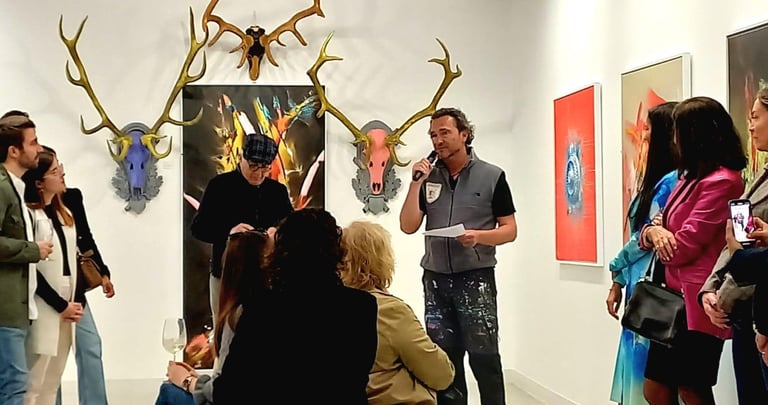 People gathered in an art gallery viewing taxidermied animal heads and colorful artworks on white walls